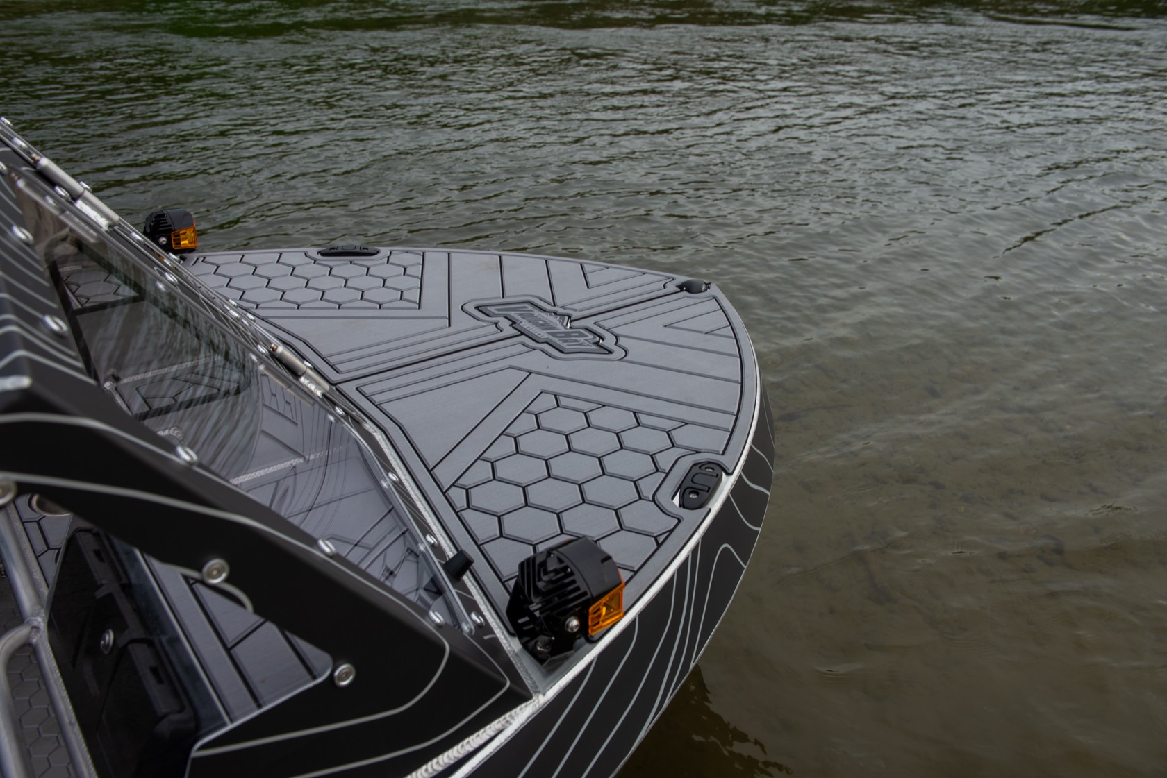 Bow deck detail showing the grey hex non-skid pattern, embossed logo and an amber pod light