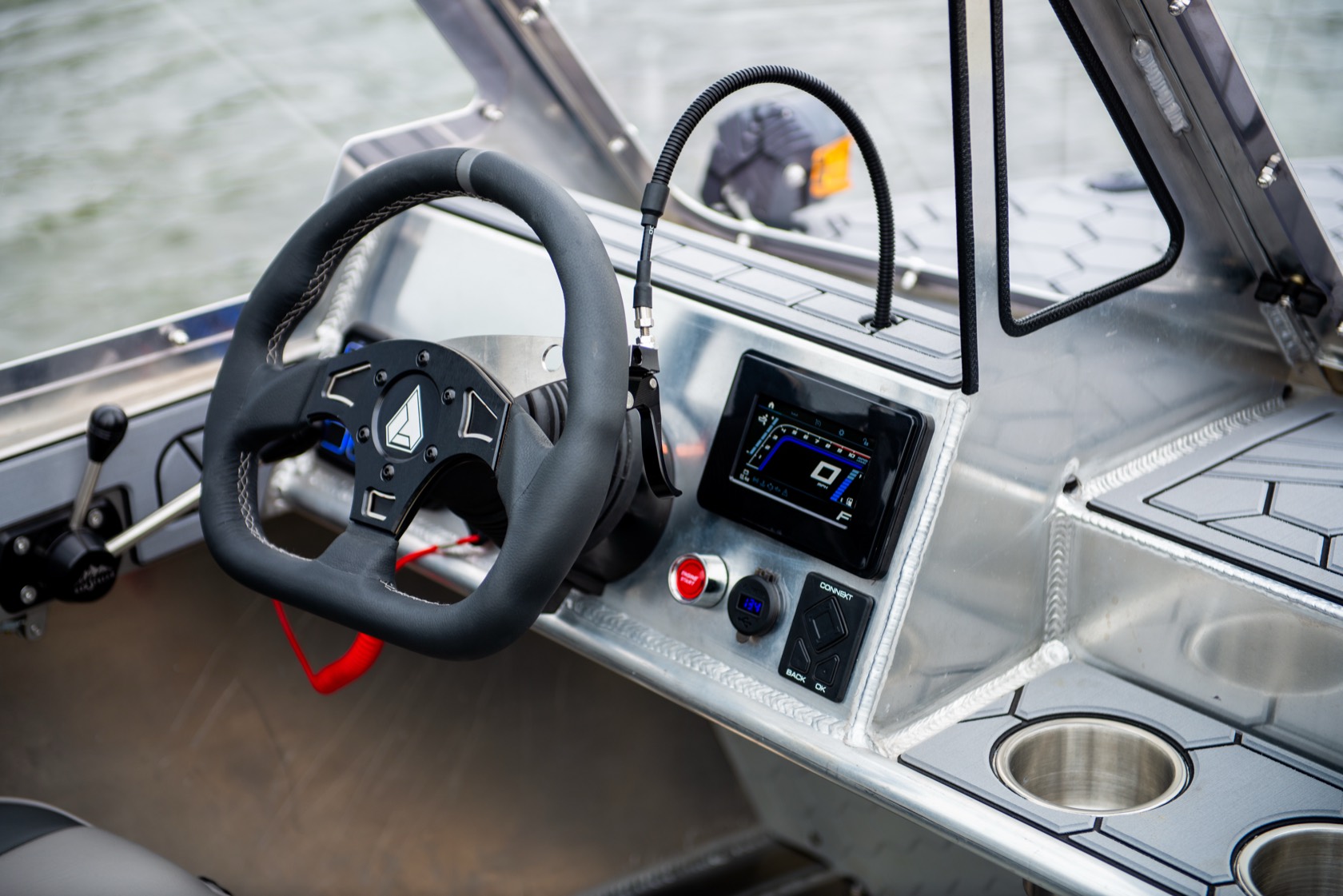 Helm of the jet boat with a flat-bottom steering wheel, digital display and switch panel