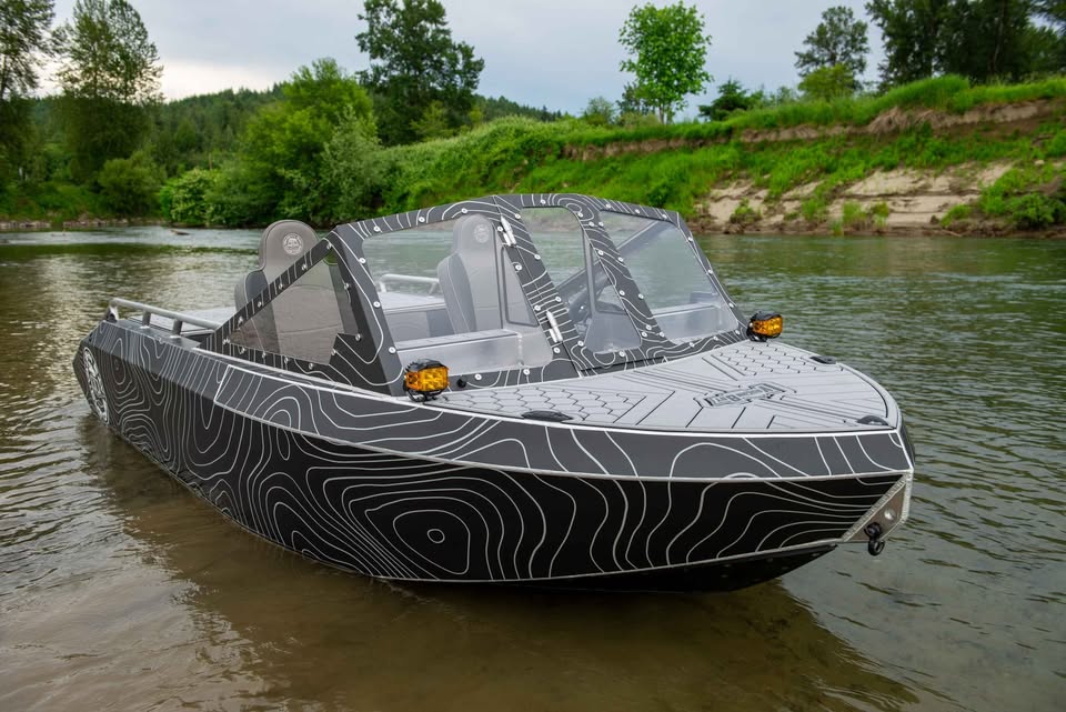 Front-quarter view of the VB12 show boat on the river with headlights and windshield