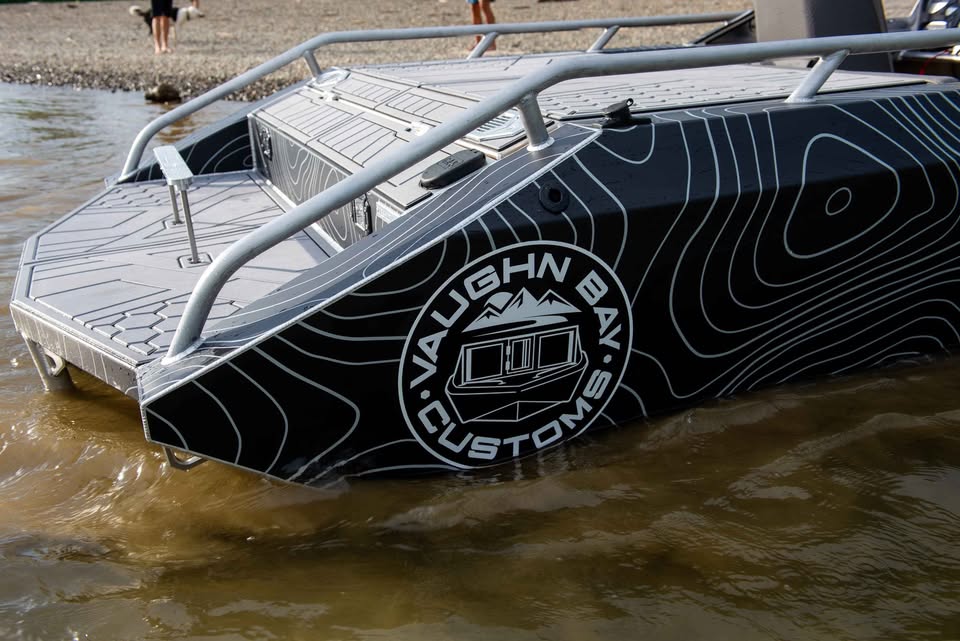Stern-quarter detail of the VB12 show boat with the circular Vaughn Bay Customs logo and rear deck