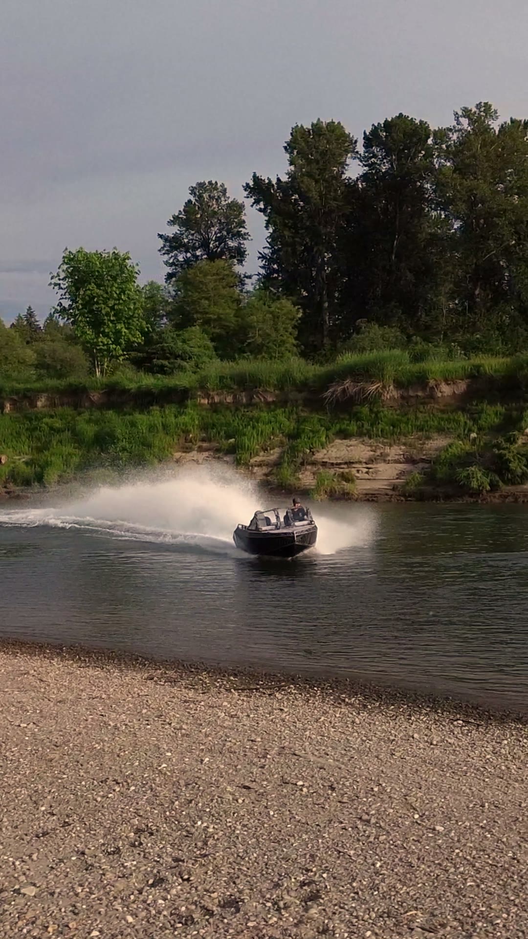 A Vaughn Bay Customs jet boat running the river and throwing spray — play the film