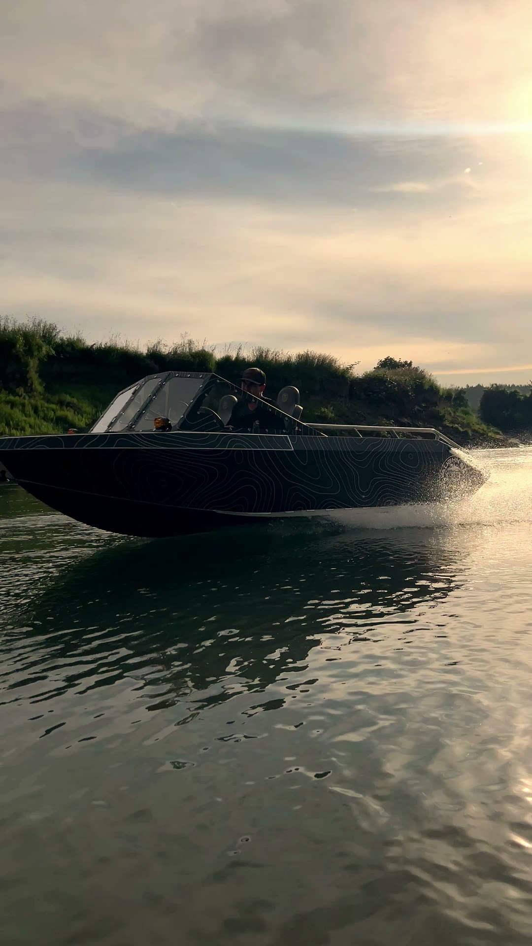 The topo-wrap Vaughn Bay Customs jet boat running the river at golden hour — play the reel